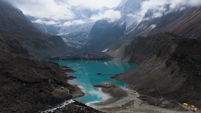 Mountain lake reflection. a view of a clear lake under the foot of a snowy mountain surrounded by mountains. Beautiful Mountain Lake in Nepal. A snowy mountain with Glacial Lake