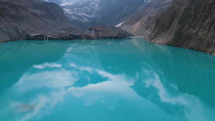 Mountain lake reflection. a view of a clear lake under the foot of a snowy mountain surrounded by mountains. Beautiful Mountain Lake in Nepal. A snowy mountain with Glacial Lake