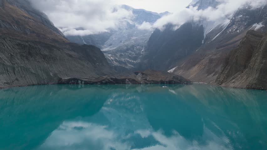 Mountain lake reflection. a view of a clear lake under the foot of a snowy mountain surrounded by mountains. Beautiful Mountain Lake in Nepal. A snowy mountain with Glacial Lake