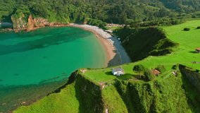 Aerial view of a small hermitage surrounded by stunning nature of Asturias in northern Spain. Ermita de la Regalina on the steep cliffs of the Cantabrian Sea coast. Beautiful Playa de Cadavedo beach - Powered by Shutterstock - Get 15% off with code: PIKWIZARD15