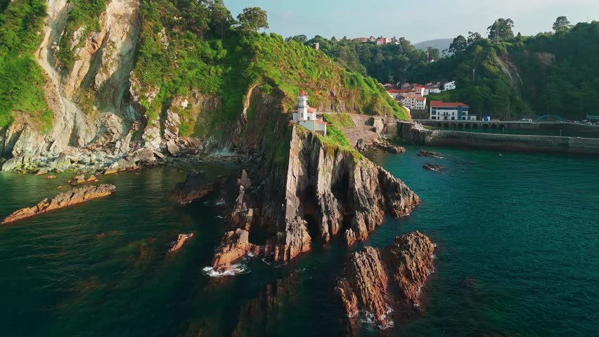 Aerial view of the picturesque Cudillero fishing village in Asturias, northern Spain. Historic lighthouse perched on the rugged Cantabrian Sea coast.