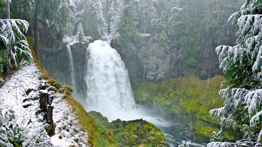 Winter Waterfall Cascading Through Snow-Covered Forest
