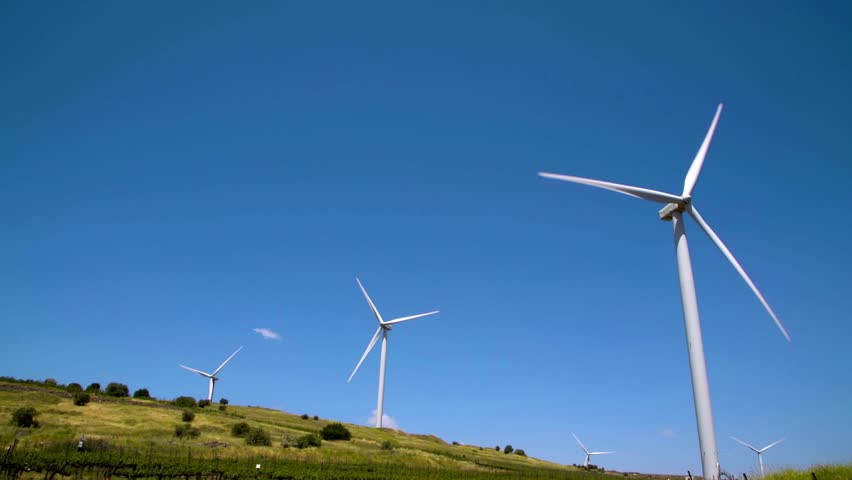 Wind turbines turning against a dark blue sky in the Golan Heights in northern Israel