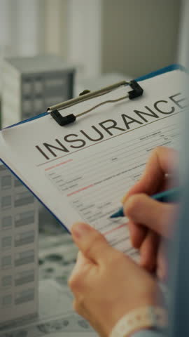 A professional insurance agent is filling out a registration form for a real estate insurance policy. This takes place in an office setting, emphasizing thoroughness in completing necessary paperwork