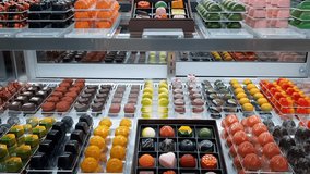 Colorful Assorted Dessert Pastry Candy Chocolate Pudding Mochi Display Row Sweet Modern Indoor Bakery Showcase Delicious Flavor Strawberry Vanilla Tiramisu Greentea Shop Mall Lighting Panning Gourmet - Powered by Shutterstock - Get 15% off with code: PIKWIZARD15