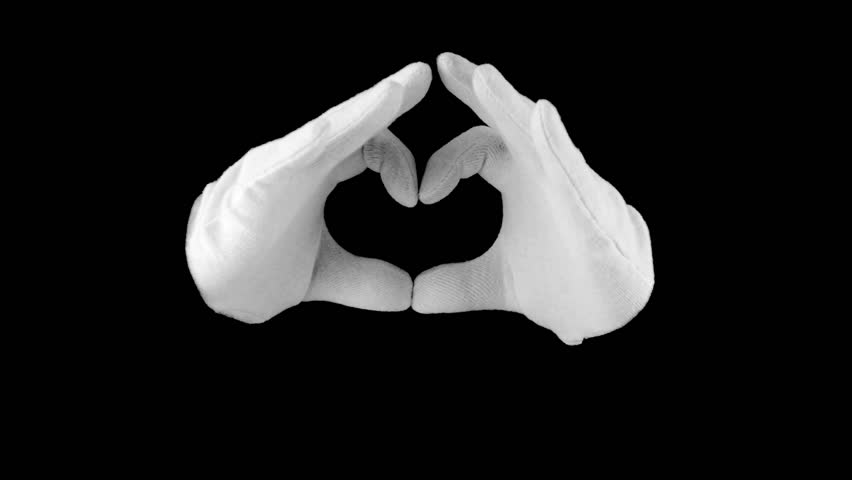Black background. Hands in white gloves, formed in the shape of the heart and
