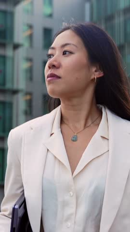 Confident Asian business woman walking in outdoors office empowered female executive enjoying successful corporate career