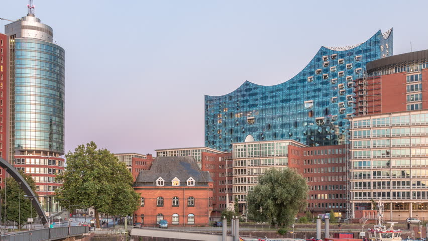 Jan Fedder Promenade day to night transition timelapse hyperlapse in Hamburg, Germany, a vibrant waterfront area. Ships and boats on the Elbe River after sunset with famous buildings in background