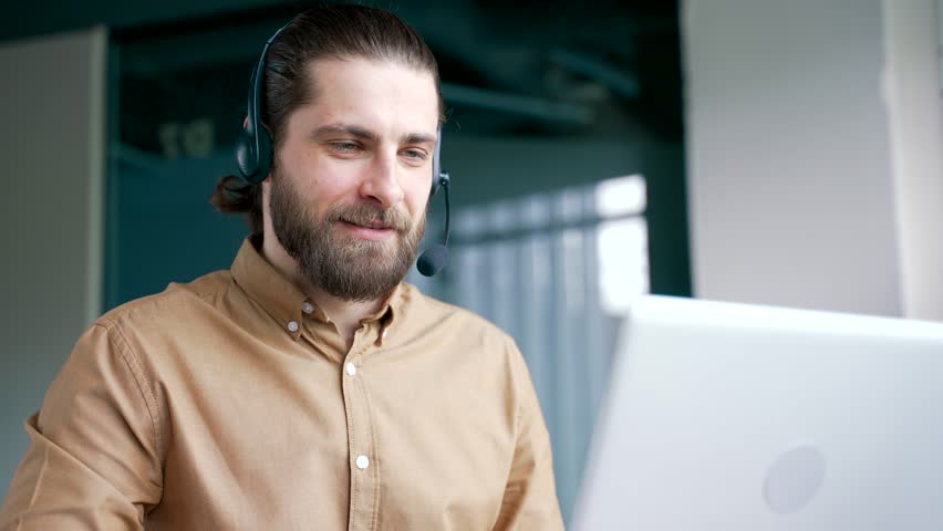 Corporate operator in headset working in customer support service on helpline telesale talking using laptop in business office. Agent of call center advises the client by answering questions. Close up - Powered by Shutterstock - Get 15% off with code: PIKWIZARD15
