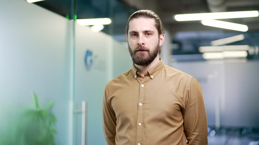 Serious businessman showing crossed arms, X sign, shaking a no sign with his head standing in modern business office looking at camera. Man demonstrates a gesture of prohibition, denial, disagreement