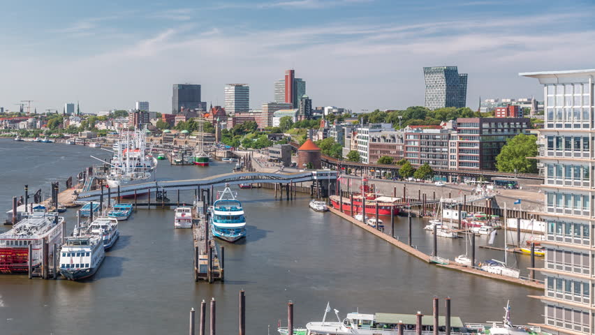 Aerial timelapse of Elbe riverside in Hamburg, Germany. Scenic view to waterfront with boats near the pier, Jan Fedder Promenade, marina and ships passing by. Vibrant cityscape by the Elbe River