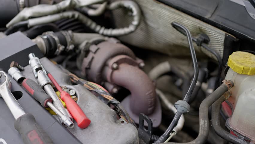 A detailed closeup view of an automotive turbocharger showcased in an engine bay setting