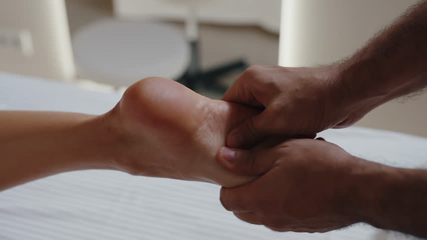 Therapist performing deep foot massage therapy