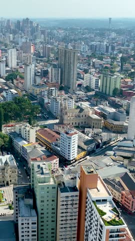 Curitiba in Parana, Brazil. Aerial View. Wonderful sunset with views of buildings and Tangua Park. Lake with reflection. Vertical video.