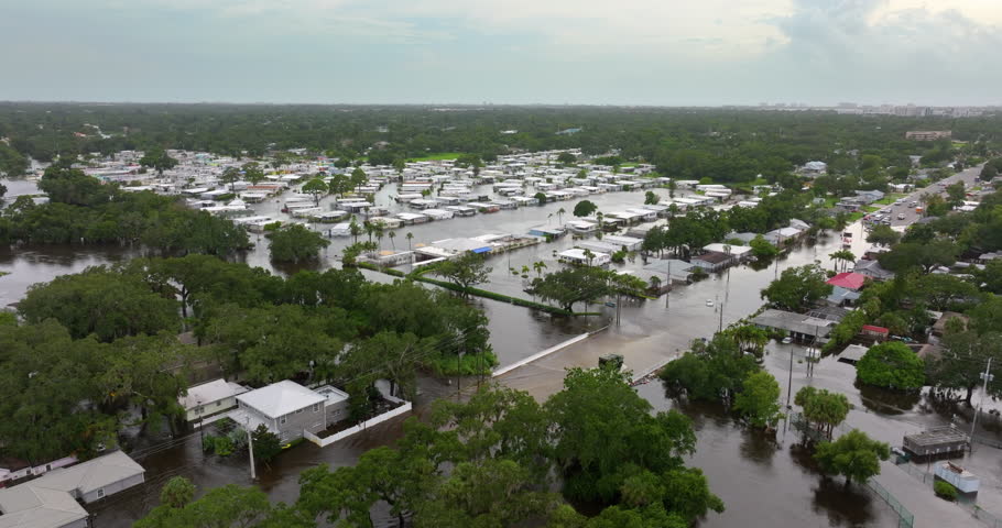 Emergency response after hurricane Debby flooding in Sarasota, Florida. Rescue workers on flooded road. Aftermath of natural disaster.