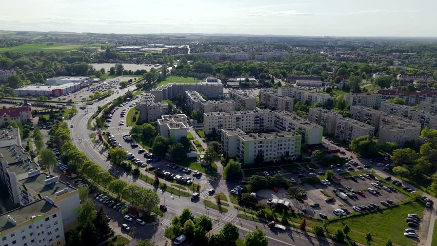 Drone footage of a residential neighborhood featuring modern homes, green spaces, and organized streets. Aerial views highlight urban planning, community living, and harmonious architecture.
