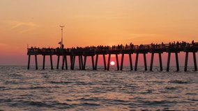 Venice, Florida. People enjoying bright sunset on fishing pier. Seaside summer activities on fresh air - Powered by Shutterstock - Get 15% off with code: PIKWIZARD15