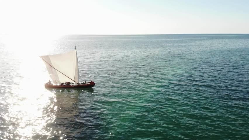 Traditional Sailing Vessel on Calm Ocean Waters Under Sunlight