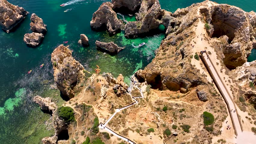 Aerial view of kayakers and boats exploring the turquoise waters and sea stacks of Ponta da Piedade in Lagos, Portugal