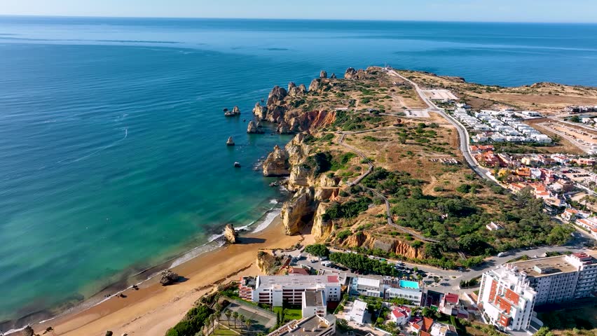 Aerial shot of the Algarve coast in Lagos Portugal with rocky cliffs and turquoise sea