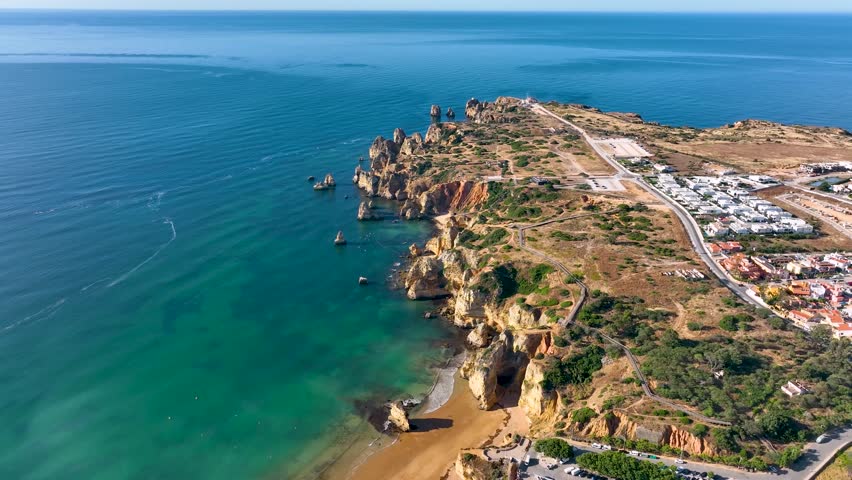 Aerial shot of the Algarve coast in Lagos Portugal with rocky cliffs and turquoise sea