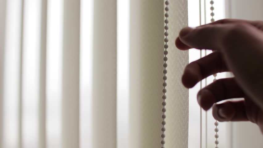 Close-Up of Hand Opening And Closing Vertical White Blinds at the Window, soft natural light filtering