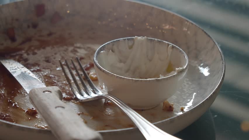 An empty plate set with cutlery and a dipping bowl for sauces or snacks