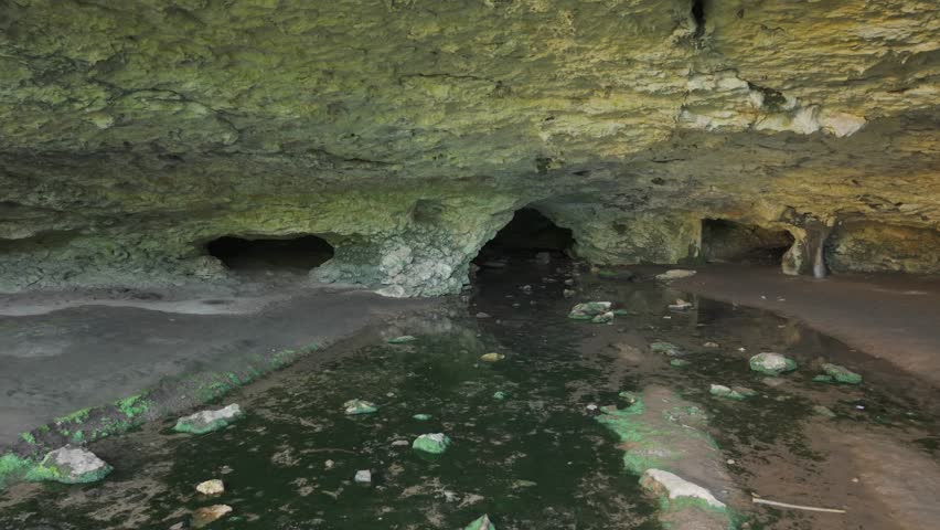 A zoom shot with a stabilized camera of a water cave entrance