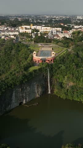 Curitiba in Parana, Brazil. Aerial View. Wonderful sunset with views of buildings and Tangua Park. Lake with reflection. Vertical video.
