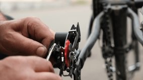 Close-up of a bicycle technician s hands installing a gear shift cable on the rear axle of a bike. Seasonal maintenance, adjustment, and repair of cycling equipment and transmission systems - Powered by Shutterstock - Get 15% off with code: PIKWIZARD15