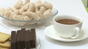 Assortment of food and drink: green peppers, pickles, tea, juice, chocolate, biscuits, puffed snacks. Diverse selection displayed on a clean white background for comparison or choice. - Powered by Shutterstock - Get 15% off with code: PIKWIZARD15