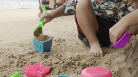 Children happily build sandcastles on the beach under the warm sunlight, creating joyful holiday memories with family and friends. 4k video footage - Powered by Shutterstock - Get 15% off with code: PIKWIZARD15