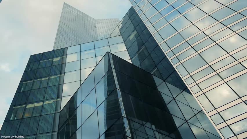 Modern Corporate Buildings with Glassed office building exterior with sky reflection in the windows.