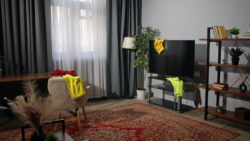 Daily lifestyle concept. Older adult woman spending time at home, housekeeping time on weekend, woman in the living room taking scattered laundry clothes into the basket.