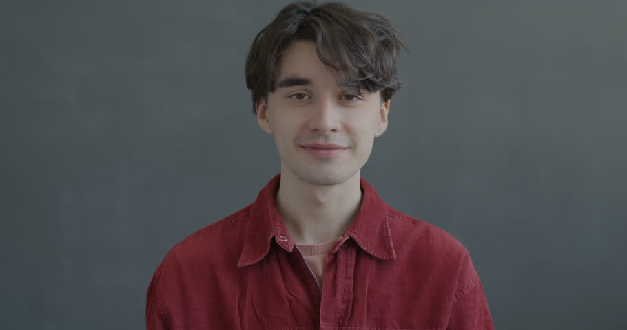 Portrait of excited young man looking at camera with open mouth feeling happy and overjoyed on black color background. People and good mood concept.