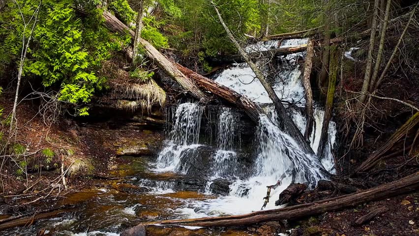 Wagner Falls flowing through forest at Pictured Rocks National Lakeshore in Michigan showing natural beauty and peaceful woodland.