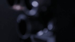 Close-up: vintage movie camera lens turret. Rack focus reveals a tangled pile of unspooled film strip in the dimly lit background. Evokes nostalgia, analog filmmaking. - Powered by Shutterstock - Get 15% off with code: PIKWIZARD15