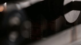  Macro shot: Vintage film strips glide through intricate projector or scanner rollers. Evokes cinema nostalgia and analog processes. Perfect for archival, retro, or filmmaking themes. - Powered by Shutterstock - Get 15% off with code: PIKWIZARD15