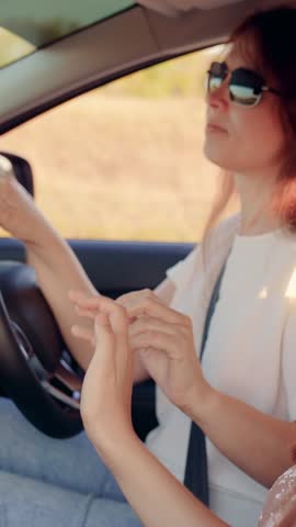 Female students driving in car listening to musical song on way sing dance. Two happy women in car are smiling, traveling, listening to radio driving towards happiness. Concept youth friendship travel
