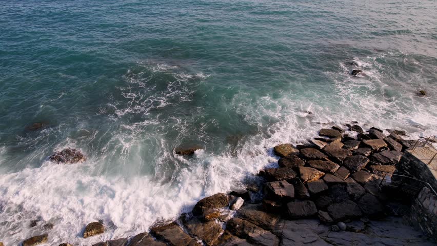 Experience tranquility of sea with this stunning drone footage, featuring waves rhythmically colliding with majestic rocks. For enhancing travel content, nature films, serene visual storytelling