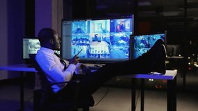 Afro American security guard watches surveillance monitors with feet on the desk - Powered by Shutterstock - Get 15% off with code: PIKWIZARD15