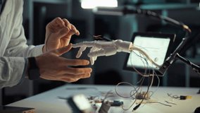 A skilled engineer connects wires to a robotic hand prototype in a modern lab, surrounded by tools and components, demonstrating creativity and technical expertise - Powered by Shutterstock - Get 15% off with code: PIKWIZARD15