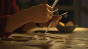 A person sits at a table surrounded by receipts and a calculator, focused on organizing their finances. The warm lighting creates a comfortable atmosphere suitable for late-night budgeting - Powered by Shutterstock - Get 15% off with code: PIKWIZARD15