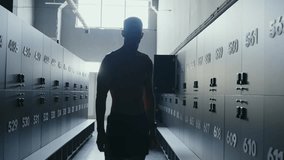 A silhouette of a male athlete standing in a gym with strong backlighting that highlights the industrial interior. The scene conveys determination and strength. Silhouetted Athlete in Gym - Powered by Shutterstock - Get 15% off with code: PIKWIZARD15