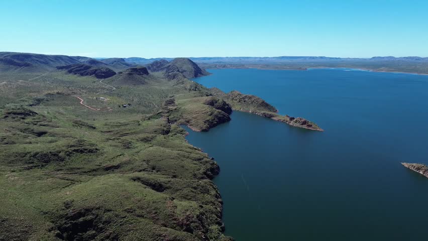 Cinematic aerial shot of Lake Argyle in Western Australia, revealing the calm water, rocky landscape and remote natural beauty.