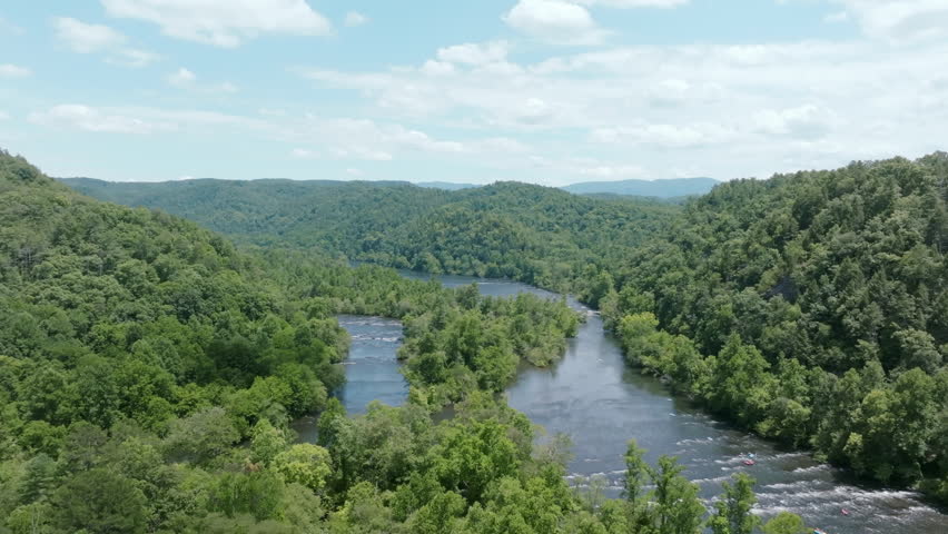 Wide aerial footage of the branching Hiawassee River in north east Tennessee during the summer with green forest all around.