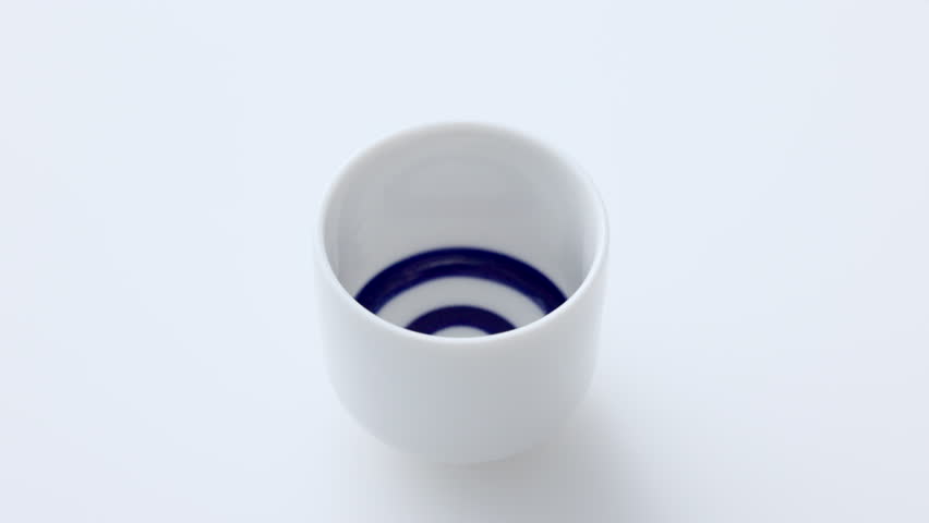Sake being poured into an ochoko(traditional Japanese sake cup)