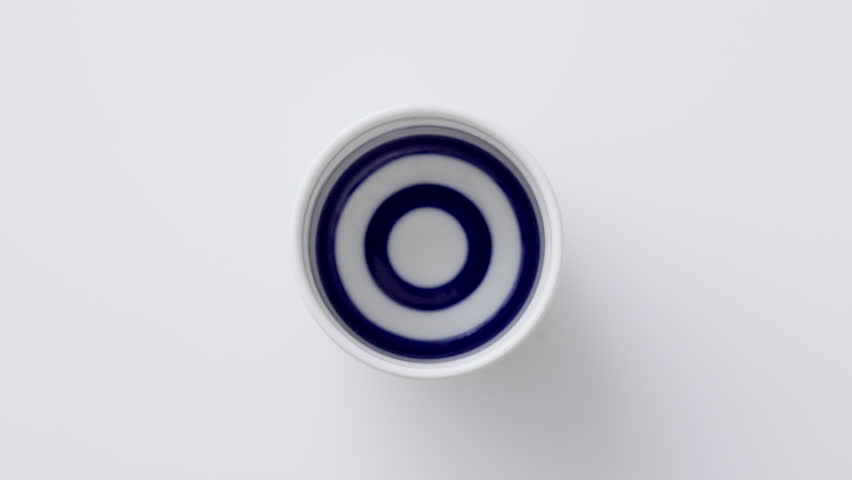 Sake being poured into an ochoko(traditional Japanese sake cup)