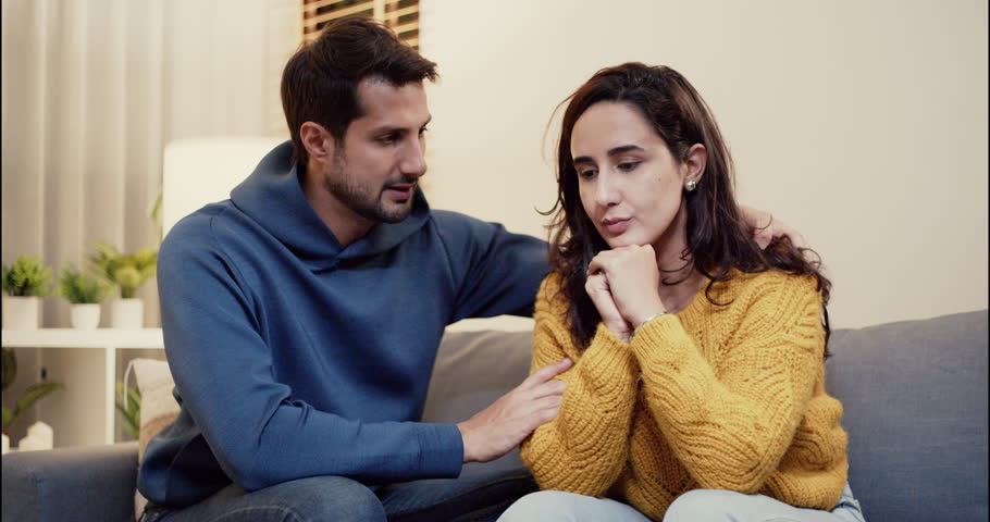 Emotional moment of a couple having a serious talk at home, showing care, concern, and support in a relationship. Ideal for themes of love, empathy, and partnership struggles.