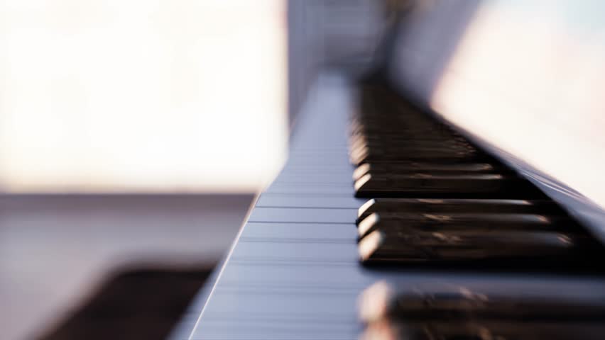 White grand piano keyboard detail and overview in a bright room with city view